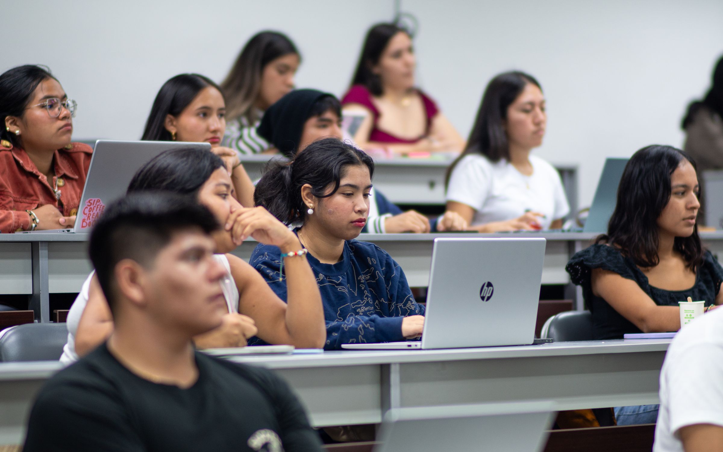 Students with laptops in a lecture hall.